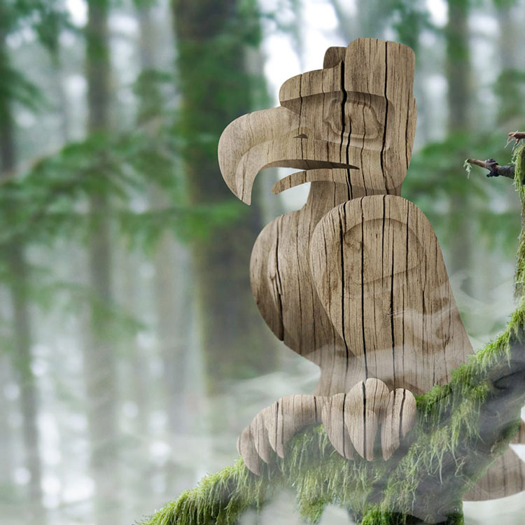 Image of misty woods on the West Coast with a branch covered in lush green moss in the foreground. The branch has a hand-carved wooden eagle statue in the West Coast Style perched upon it.